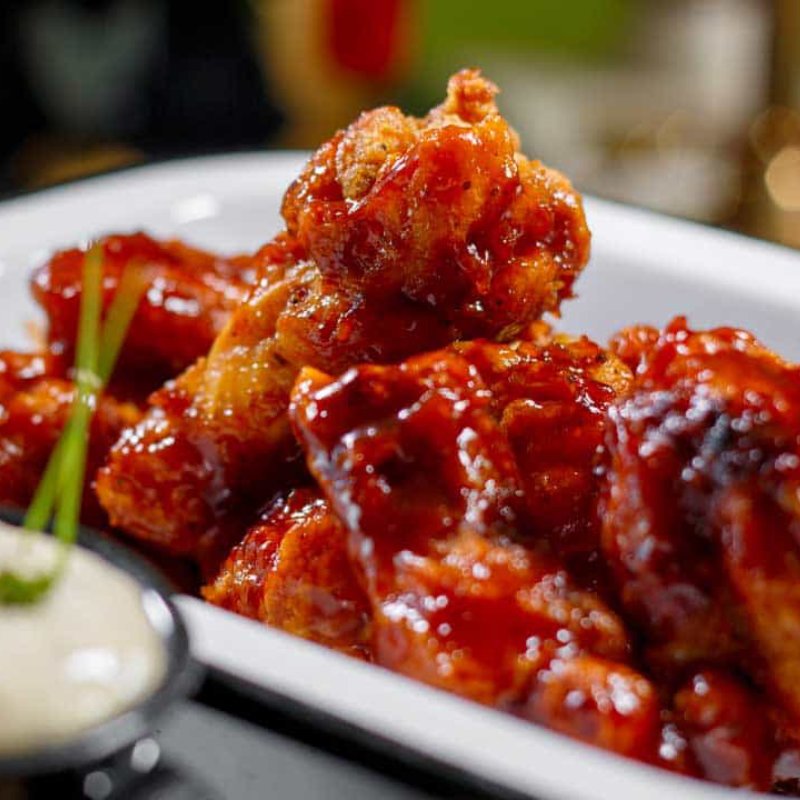 Alitas bañadas en salsa búfalo o BBQ al humo